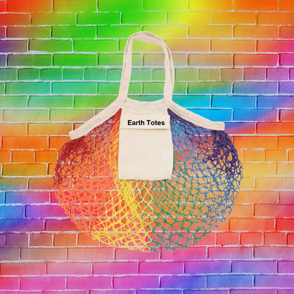 rainbow color mesh net bag with interior pocket and Earth Totes logo against rainbow color brick wall